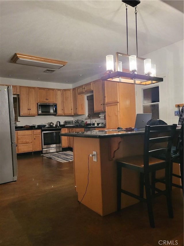 kitchen featuring pendant lighting, kitchen peninsula, a kitchen bar, sink, and appliances with stainless steel finishes