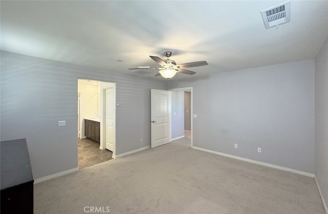 unfurnished bedroom with ceiling fan, light colored carpet, and connected bathroom