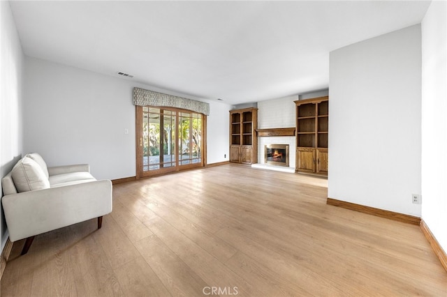 living room with a fireplace and light wood-type flooring