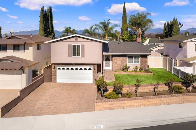 view of front of property with a garage, a front lawn, and a mountain view