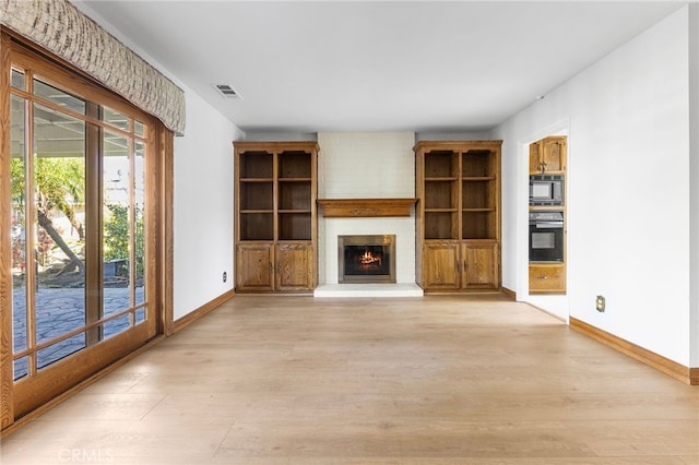 unfurnished living room with a fireplace and light hardwood / wood-style flooring