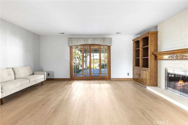 unfurnished living room featuring a fireplace and light hardwood / wood-style floors