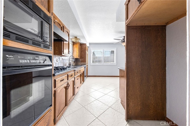 kitchen with a textured ceiling, black appliances, tasteful backsplash, ceiling fan, and sink