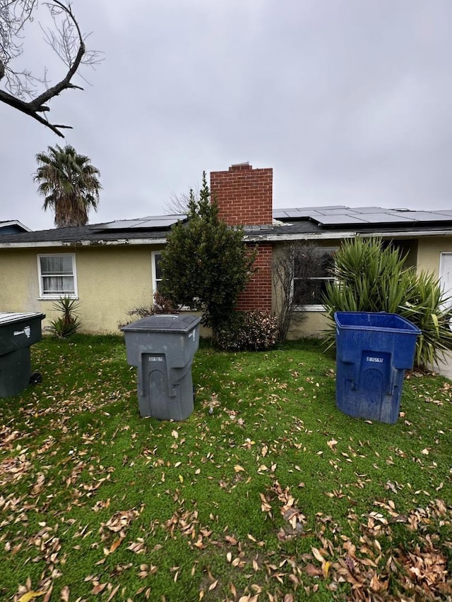 exterior space featuring a yard and solar panels