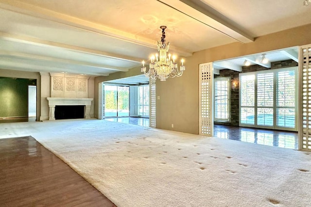 unfurnished living room featuring carpet flooring, an inviting chandelier, beamed ceiling, and a fireplace