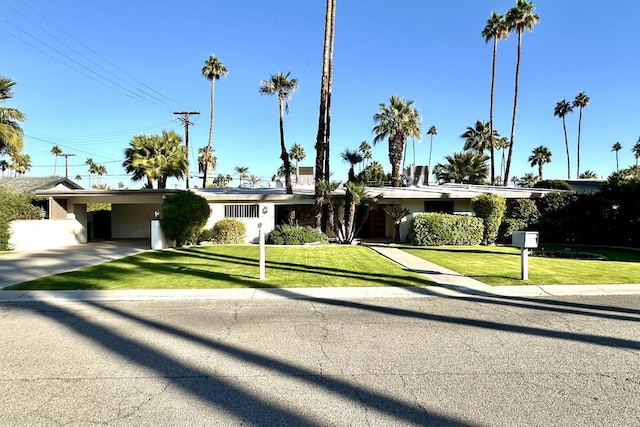 single story home featuring a front lawn and a carport