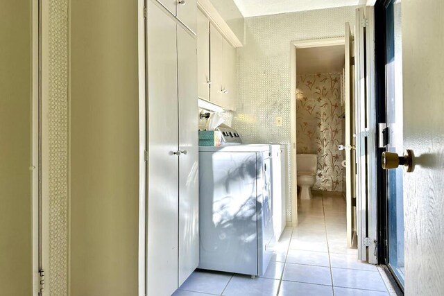 washroom featuring light tile patterned floors and washing machine and clothes dryer