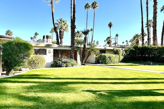 view of front facade featuring a front lawn and central air condition unit