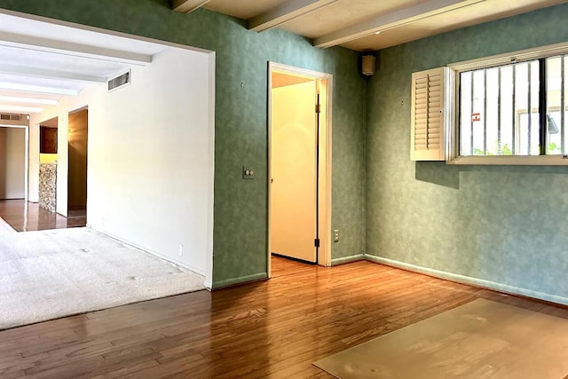 spare room with hardwood / wood-style flooring and beam ceiling