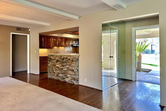 interior space with exhaust hood, dark wood-type flooring, and beam ceiling