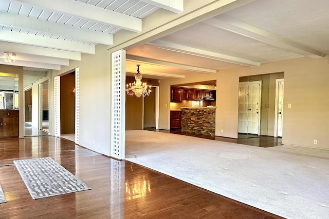 empty room with a notable chandelier, dark hardwood / wood-style flooring, and beamed ceiling