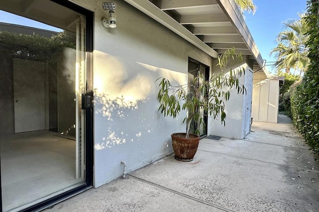 view of exterior entry with a patio area