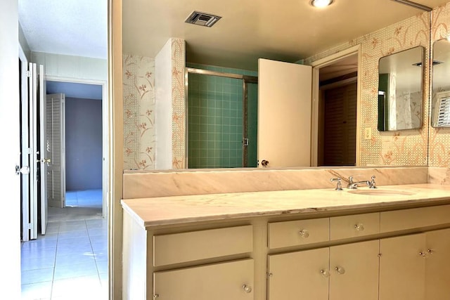 bathroom with tile patterned floors, vanity, and an enclosed shower