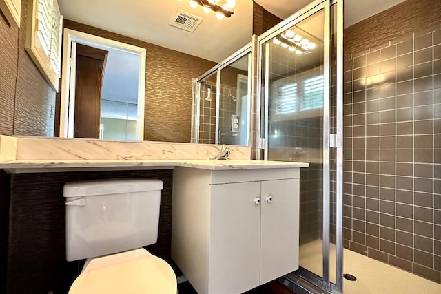 bathroom with a shower with shower door, vanity, and toilet