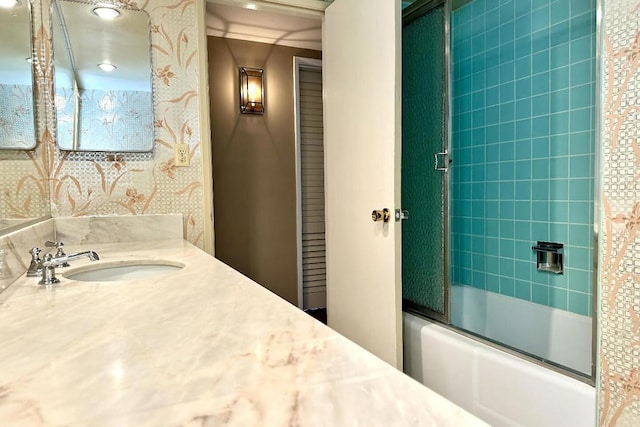 bathroom featuring combined bath / shower with glass door and vanity