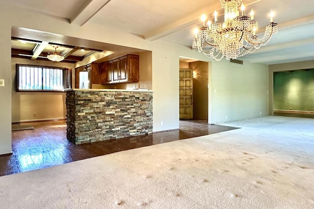 interior space with a notable chandelier, dark carpet, and beamed ceiling