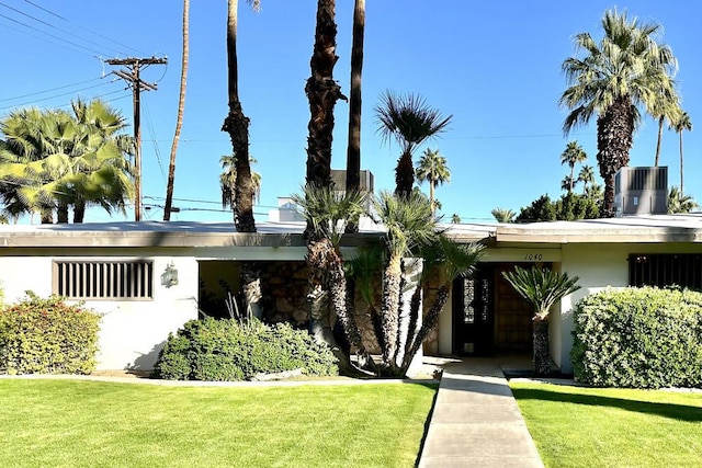 ranch-style house featuring central AC unit and a front yard