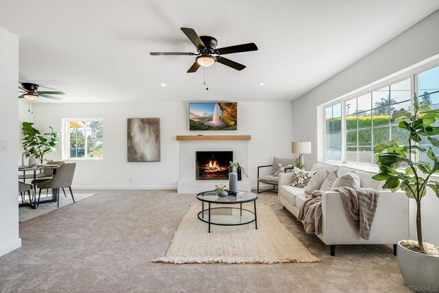 carpeted living room with ceiling fan