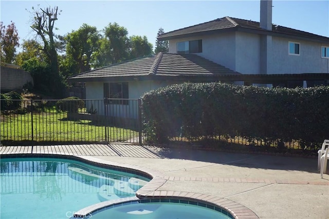 view of pool featuring a lawn and an in ground hot tub