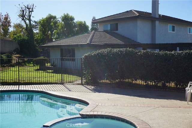 view of swimming pool featuring a pool with connected hot tub and fence