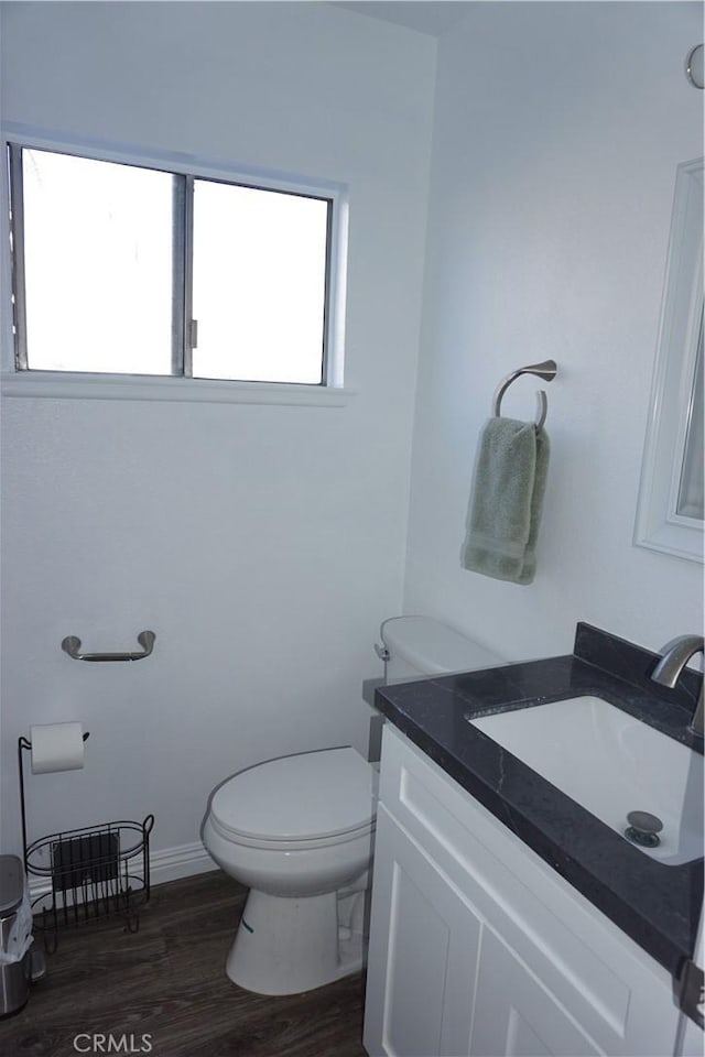 bathroom featuring vanity, wood-type flooring, and toilet