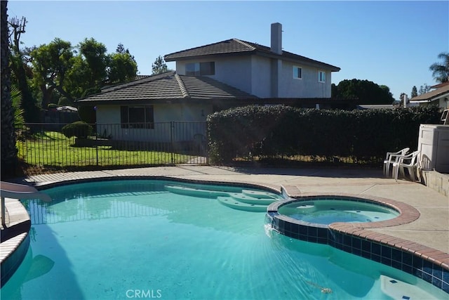 view of pool featuring a patio area, a pool with connected hot tub, a water slide, and fence