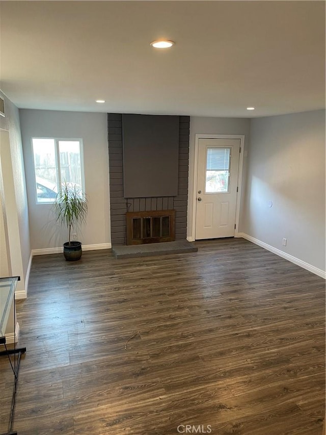 unfurnished living room featuring dark hardwood / wood-style floors and a fireplace