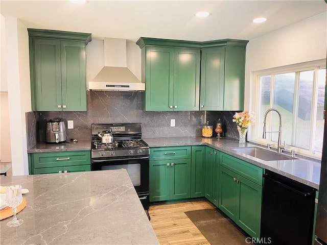 kitchen featuring wall chimney range hood, sink, light stone counters, black appliances, and light wood-type flooring