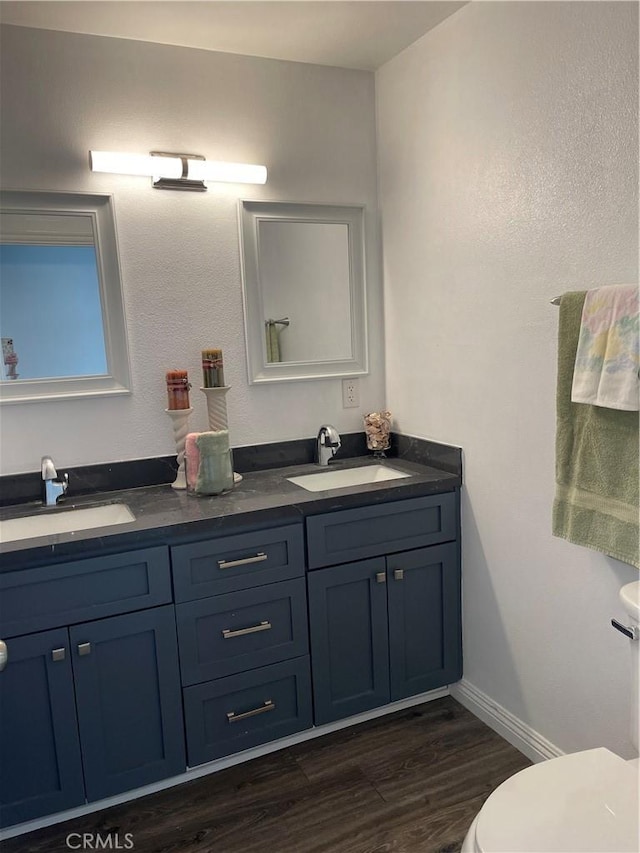 bathroom with vanity, toilet, and wood-type flooring