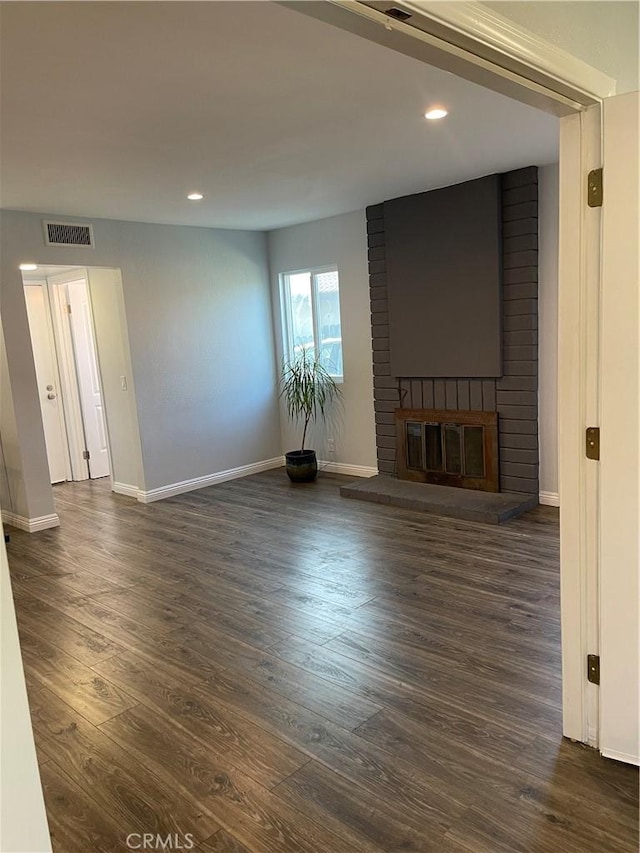 unfurnished living room featuring dark hardwood / wood-style flooring and a fireplace