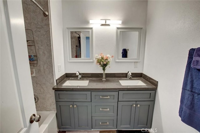 bathroom featuring double vanity, shower / bath combination, and a sink