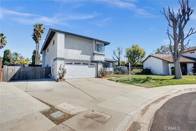 traditional-style home featuring a front lawn, an attached garage, driveway, and fence