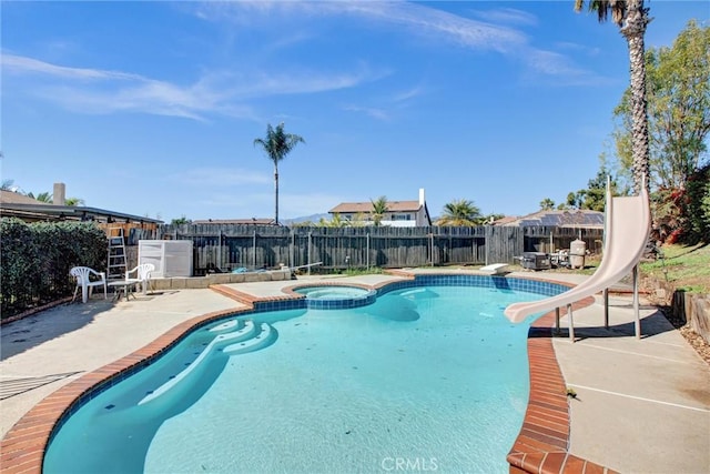 view of pool featuring a pool with connected hot tub, a patio area, a fenced backyard, and a water slide