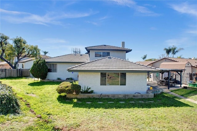 rear view of property with a yard, a patio, a pergola, and fence