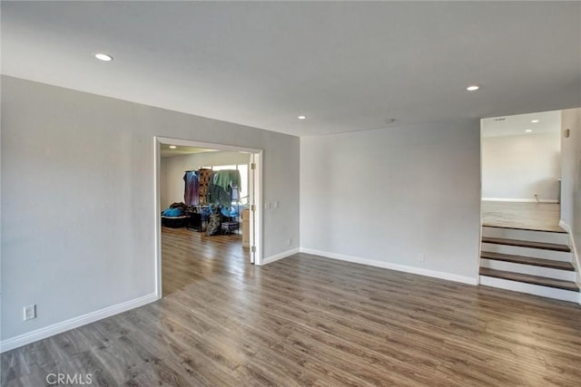 spare room featuring recessed lighting, wood finished floors, and baseboards