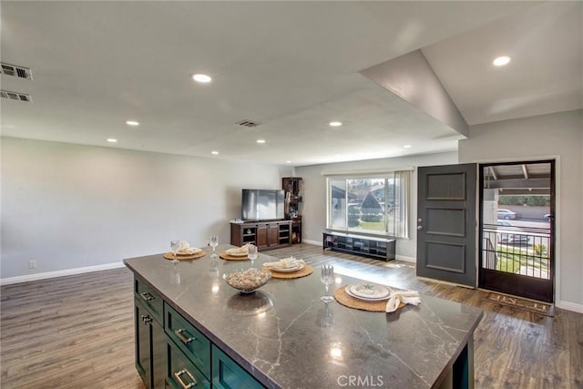 kitchen with open floor plan, recessed lighting, wood finished floors, and visible vents