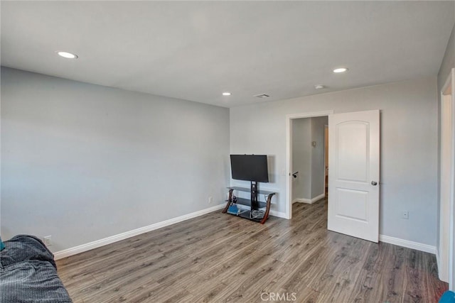 living room featuring recessed lighting, baseboards, and wood finished floors