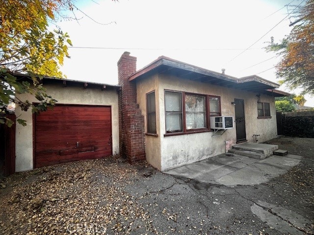 view of front of property featuring a garage and cooling unit