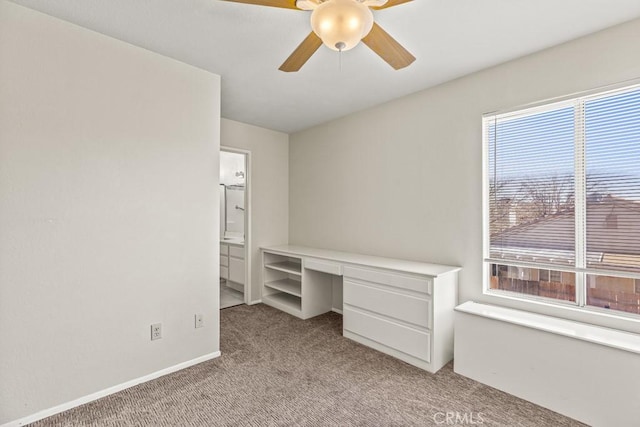 unfurnished office featuring light carpet and ceiling fan