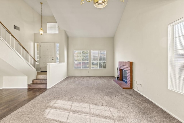 unfurnished living room featuring carpet floors, a fireplace, and high vaulted ceiling