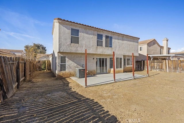 back of property with central air condition unit and a patio area