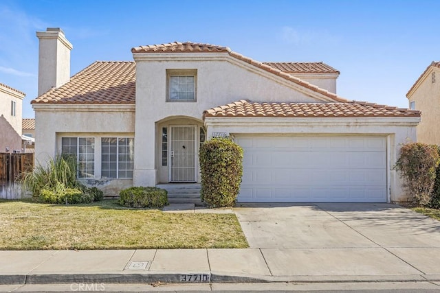 mediterranean / spanish house with a garage and a front lawn