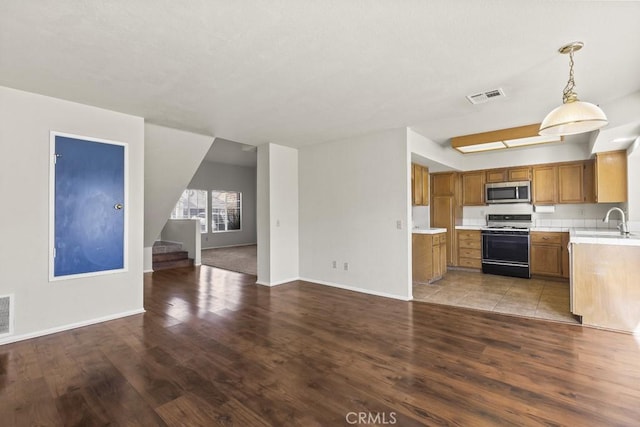 kitchen with pendant lighting, white gas range oven, and light wood-type flooring