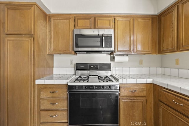 kitchen with gas range and tile counters