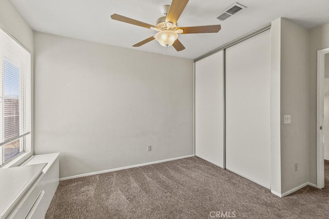 unfurnished bedroom featuring a closet, carpet, and multiple windows