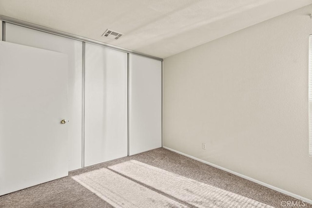 unfurnished bedroom featuring a closet and carpet flooring