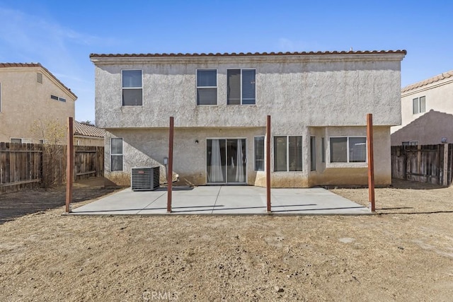 rear view of property with cooling unit and a patio