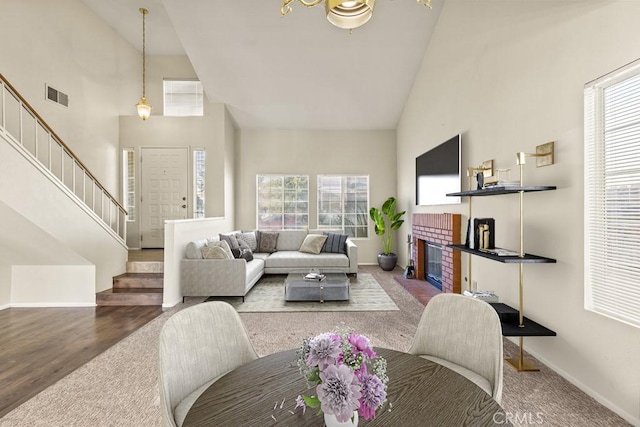 living room featuring a brick fireplace, high vaulted ceiling, and hardwood / wood-style floors