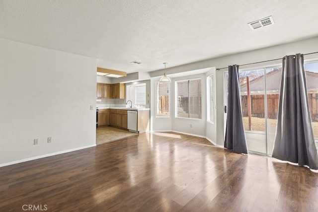 unfurnished living room featuring sink and light hardwood / wood-style flooring