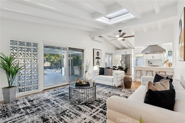 living room with ceiling fan, wood-type flooring, vaulted ceiling with skylight, and a wall mounted air conditioner